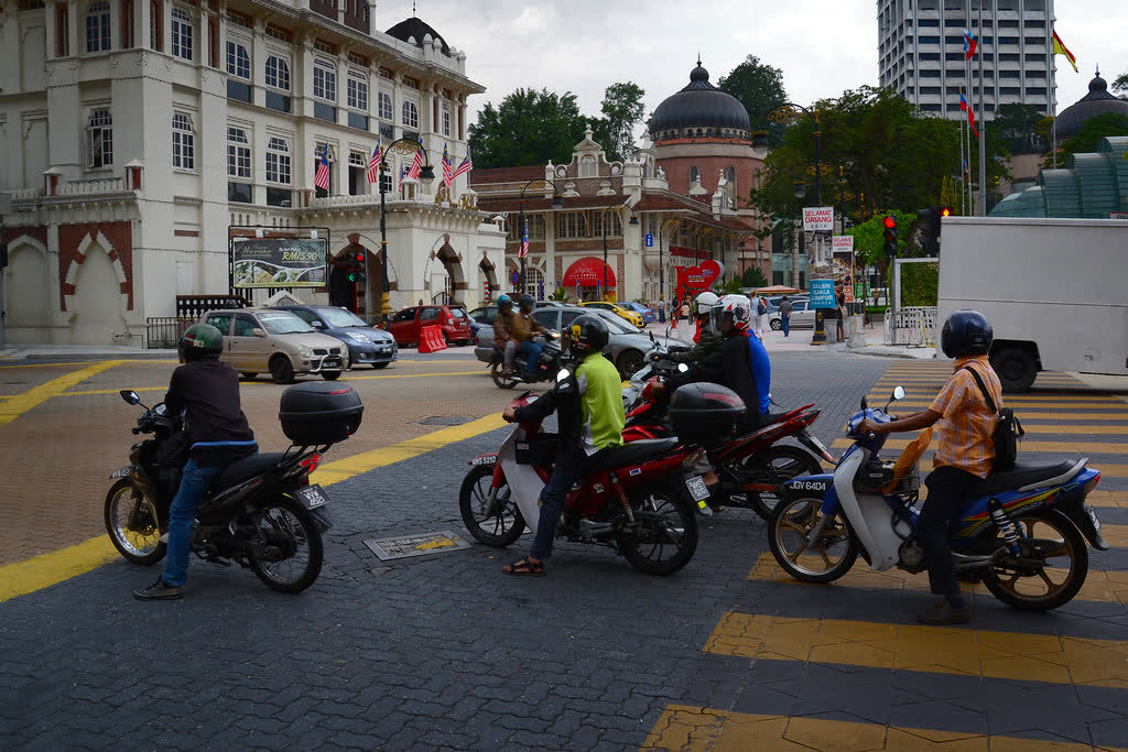 Penunggang motosikal menunggu lampu isyarat di Kuala Lumpur